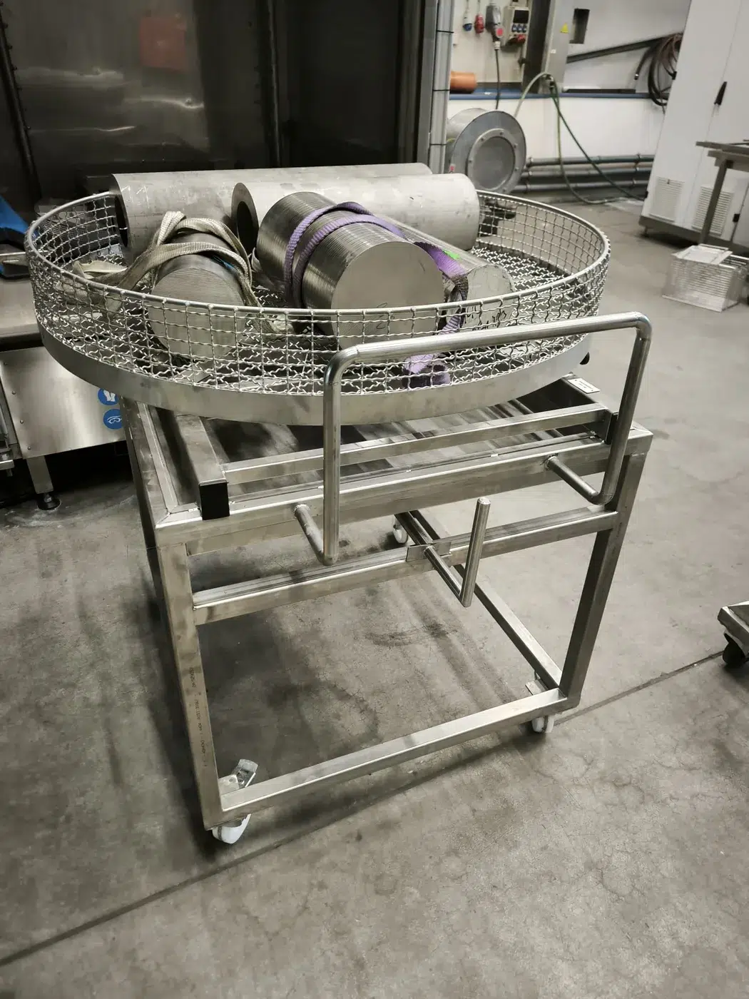 Testgewichte in einem runden Werkstückkorb vor der Reinigungsanlage