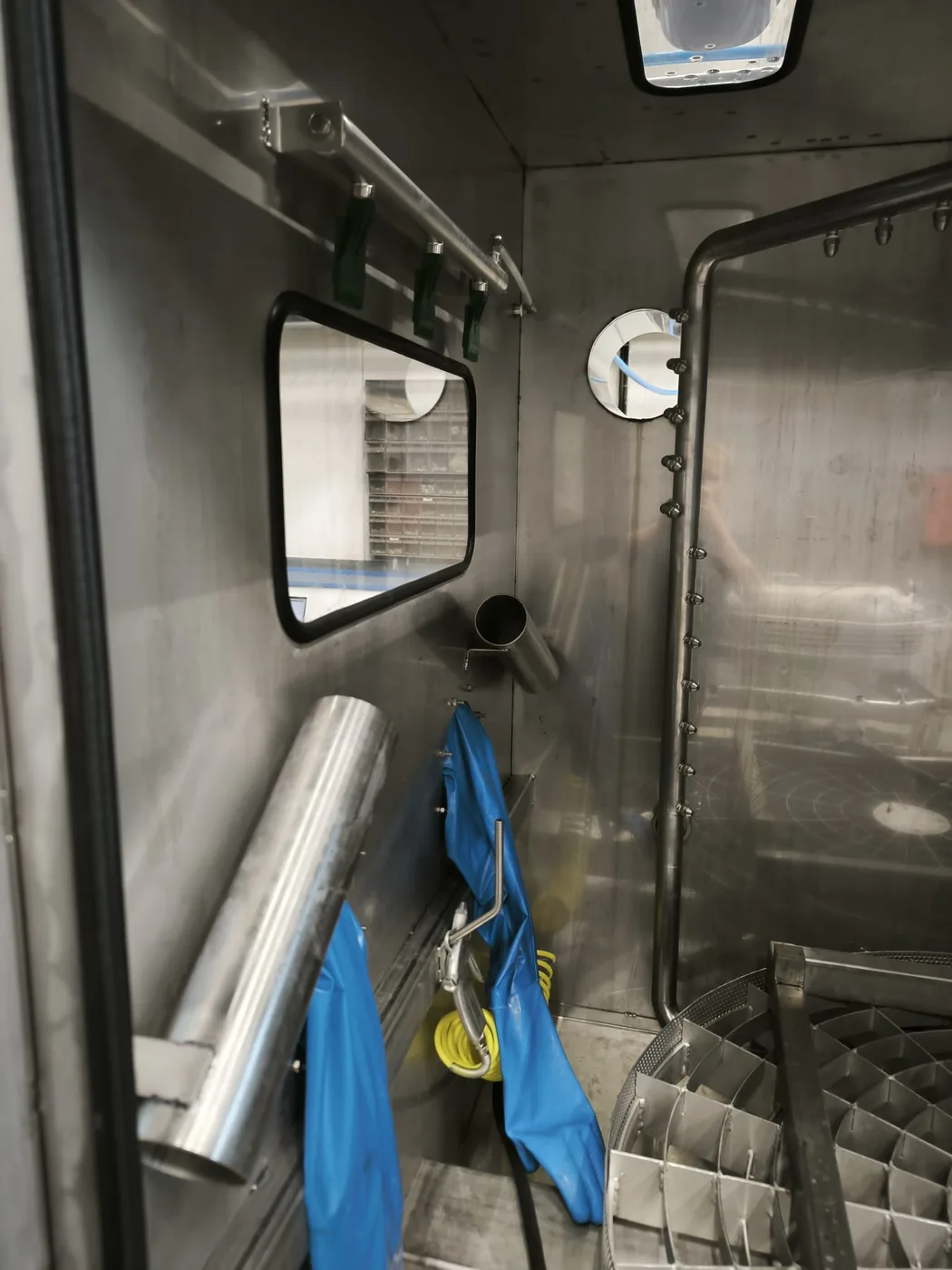 Innenraum der Hochdruck-Arbeitskammer mit Handschuhen, Werkzeug und Düsenleiste