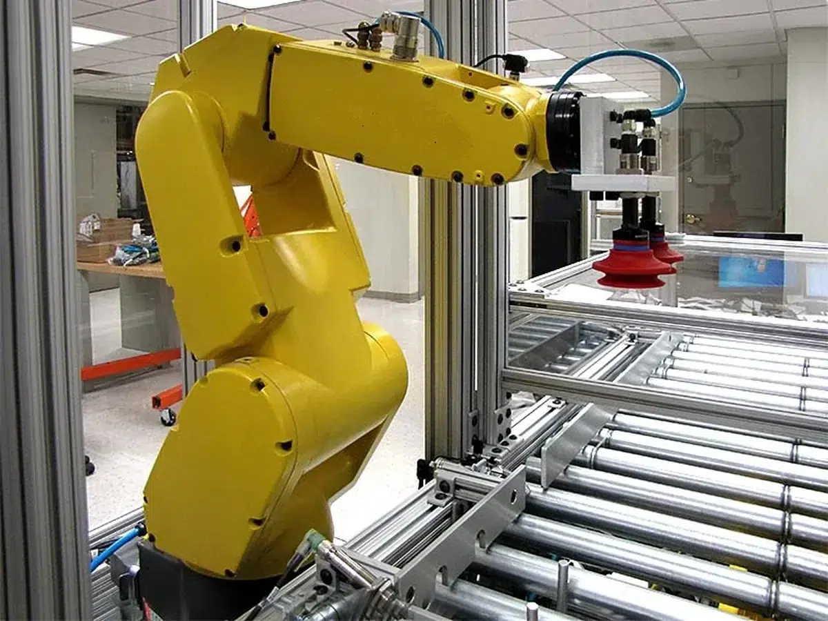 Roboter an einer Rollenbahn für die automatische Werkstückzuführung